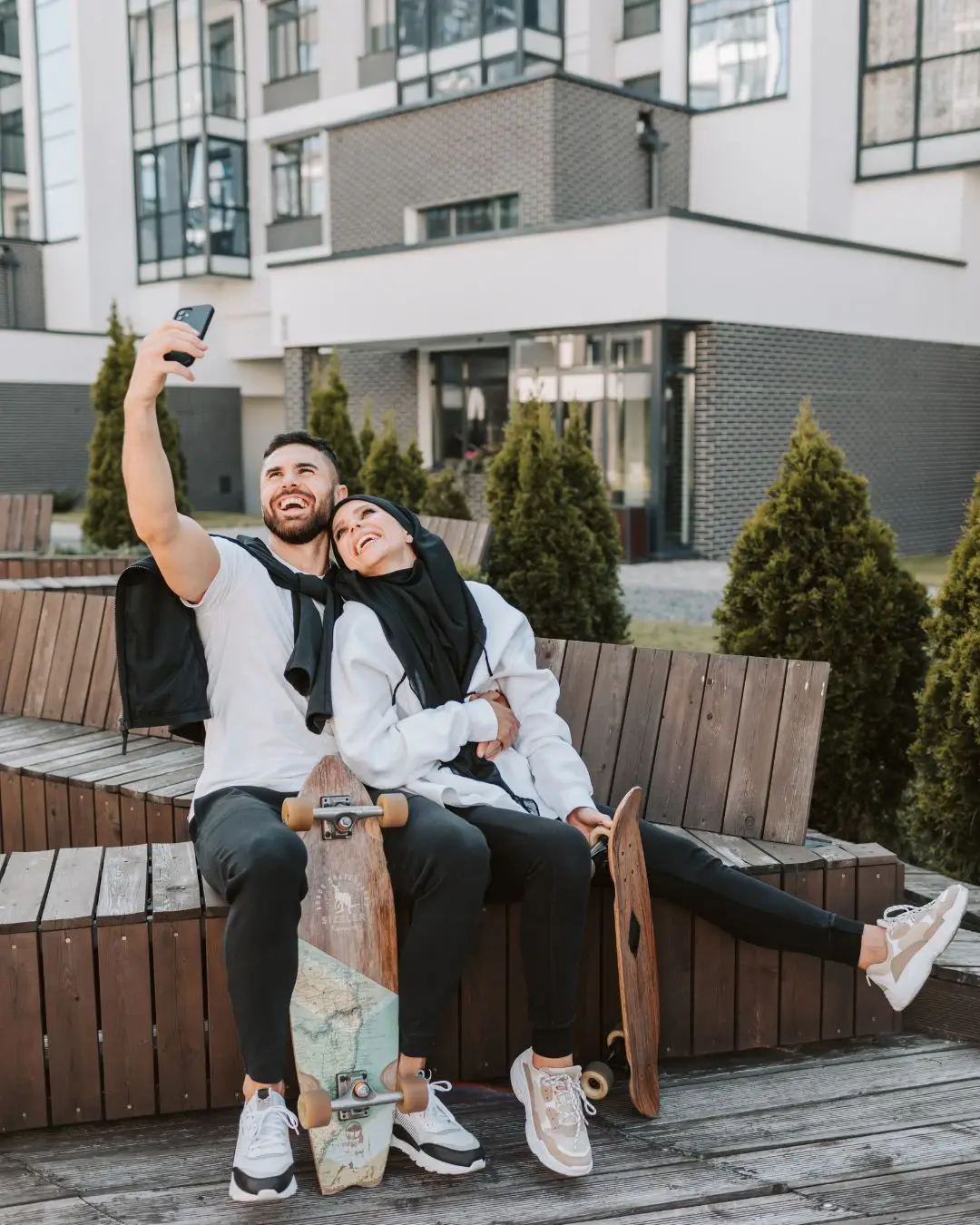 Couple Holding Skateboard While Taking Selfie