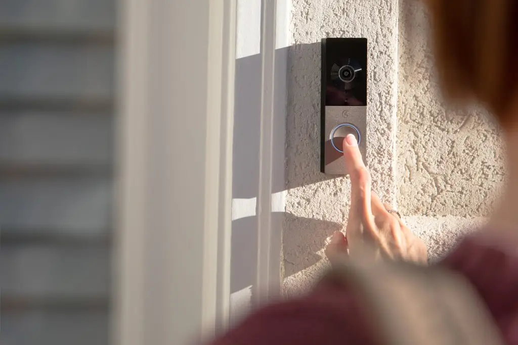 Person pressing a doorbell camera